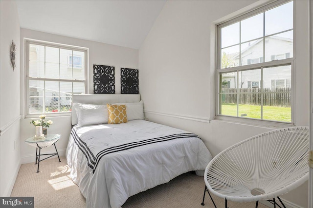 bedroom with carpet floors, baseboards, and vaulted ceiling