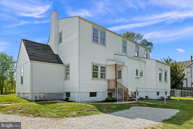 back of property featuring a lawn, fence, and a chimney