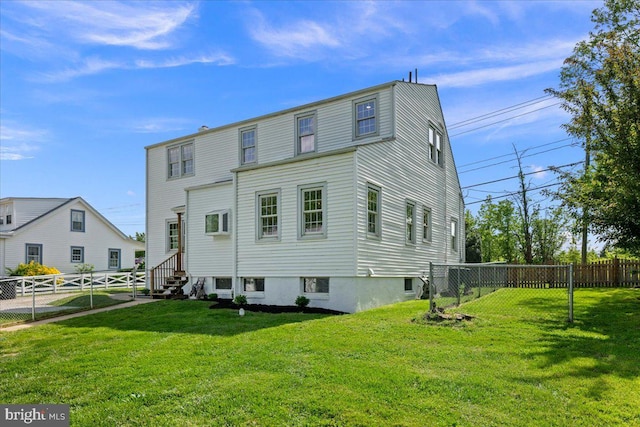 back of house featuring a fenced backyard and a yard