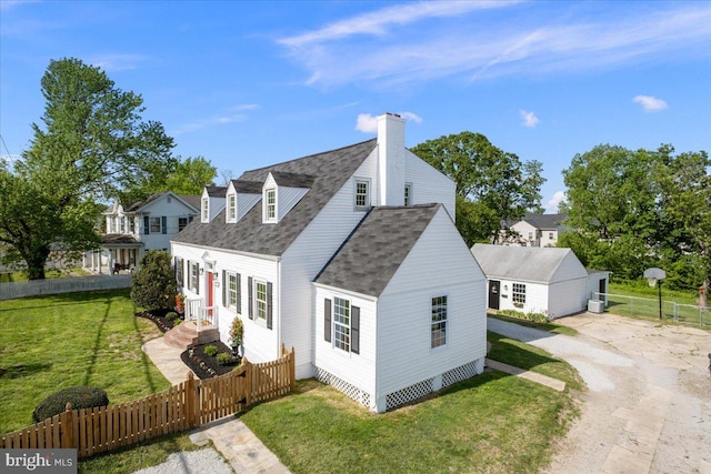 view of side of home with a shingled roof, a chimney, a yard, fence private yard, and driveway