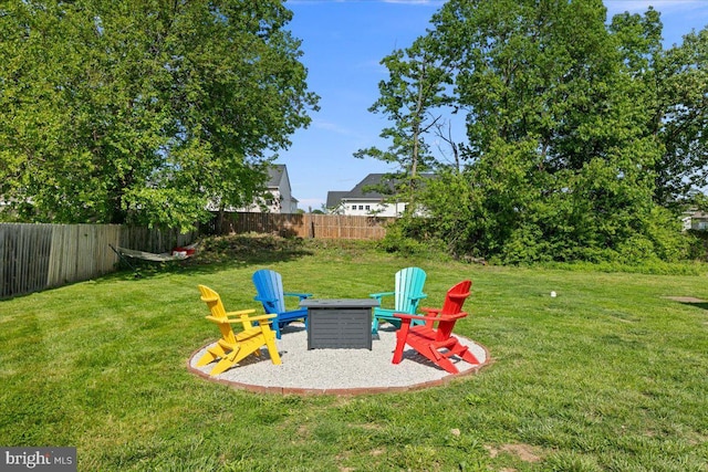 view of yard with a fenced backyard and a fire pit