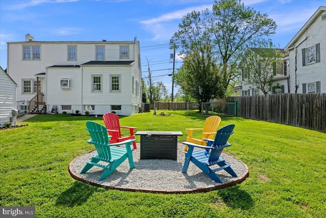 view of yard with central AC, fence, and a fire pit