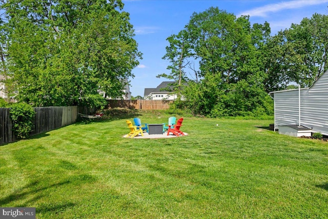 view of yard with fence and a fire pit