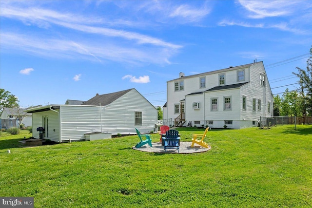 rear view of house with a yard, fence, a patio area, and an outdoor fire pit