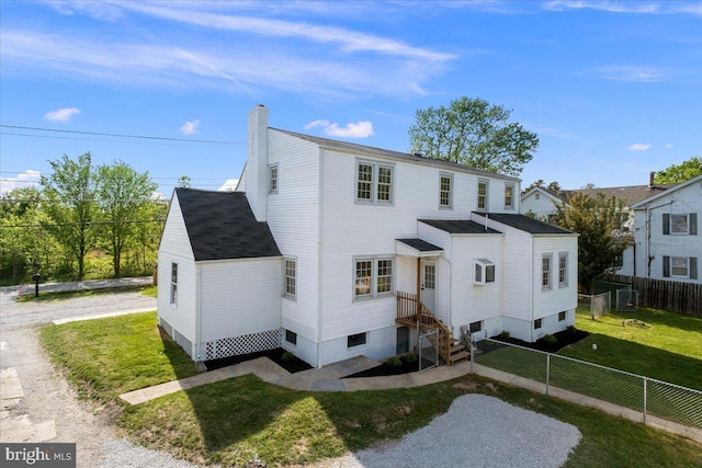 view of front of property with a fenced backyard, a front lawn, roof with shingles, and a chimney