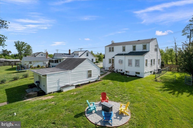 back of property with a fenced backyard, an outdoor fire pit, and a yard
