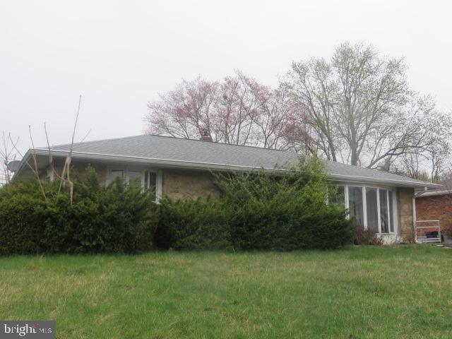 exterior space with a chimney and a front lawn
