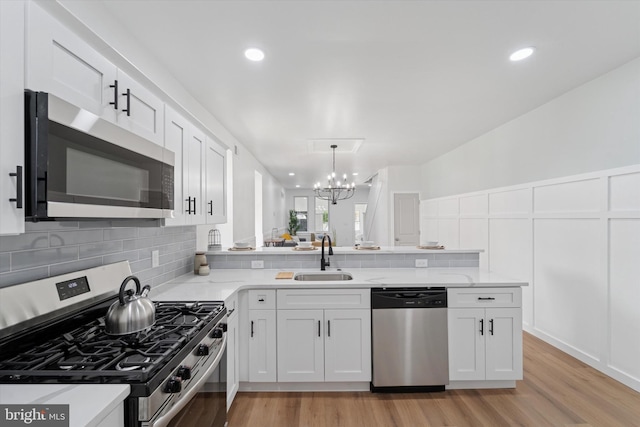 25 N Brown St, Gloucester City, NJ 08030 - kitchen featuring stainless steel appliances, a sink, decorative backsplash, a chandelier, and white cabinets
