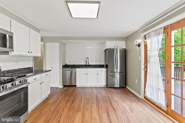 1263 Wilshire Dr, Herndon, VA 20170 - kitchen featuring appliances with stainless steel finishes, backsplash, light wood-style floors, and white cabinets