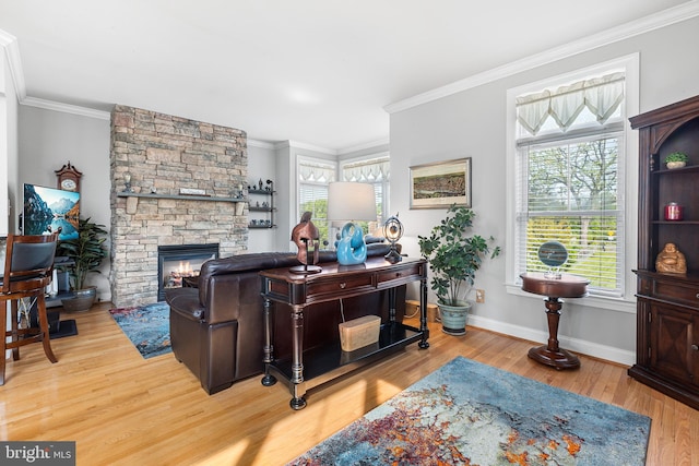 office area featuring wood finished floors, crown molding, baseboards, and a fireplace
