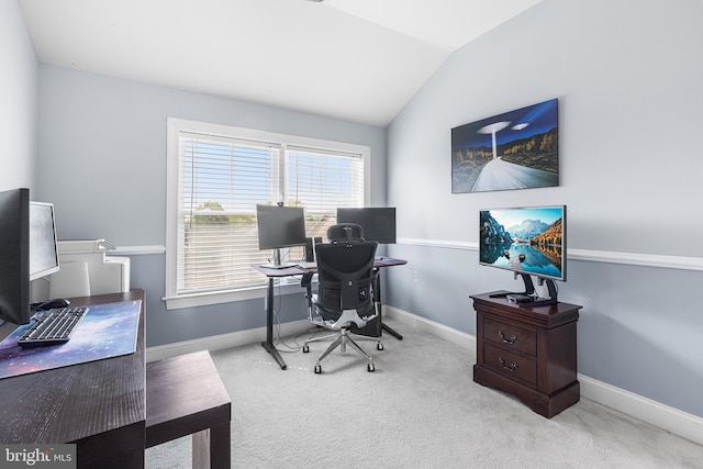 carpeted office space with vaulted ceiling and baseboards