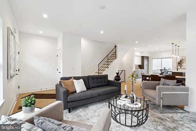 living room with recessed lighting, stairs, and baseboards