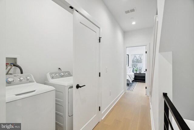 clothes washing area with washing machine and clothes dryer, laundry area, light wood-style flooring, recessed lighting, and visible vents