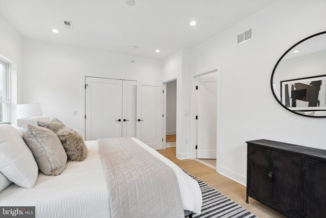 bedroom with recessed lighting, light wood finished floors, and visible vents