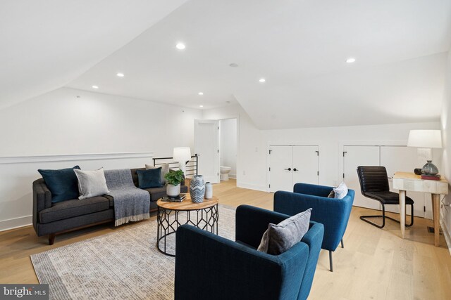 living room featuring recessed lighting, vaulted ceiling, and light wood-type flooring