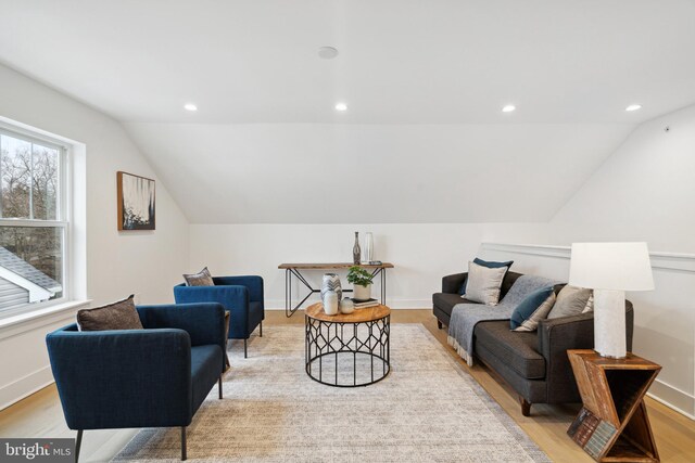 living room featuring recessed lighting, baseboards, light wood-type flooring, and lofted ceiling