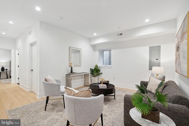 living area featuring recessed lighting, light wood-style floors, visible vents, and electric panel