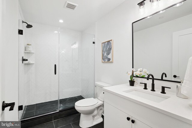 bathroom featuring toilet, tile patterned floors, a shower stall, and vanity