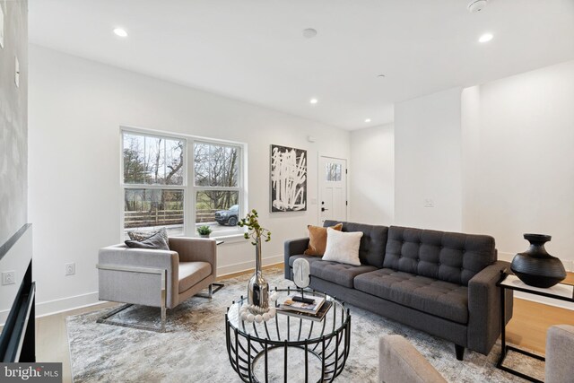 living room with recessed lighting, baseboards, and wood finished floors
