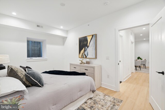 bedroom featuring light wood-type flooring, recessed lighting, baseboards, and visible vents