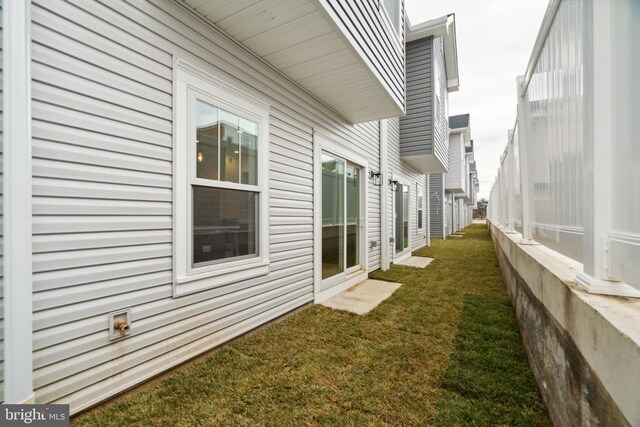 view of side of home with a yard