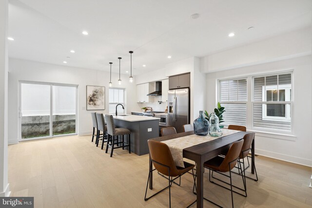 dining room featuring recessed lighting, light wood-style flooring, and baseboards