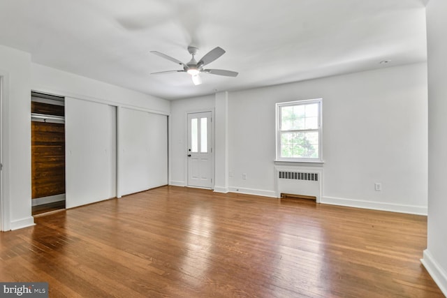 6911 Wells Pkwy, University Park, MD 20782 - unfurnished bedroom with radiator heating unit, wood finished floors, baseboards, and a ceiling fan