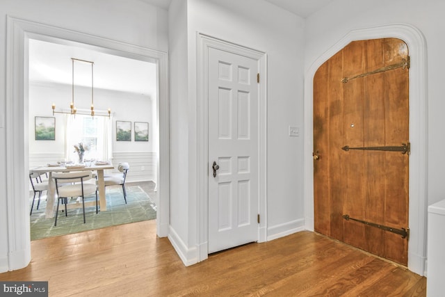 6911 Wells Pkwy, University Park, MD 20782 - foyer featuring wood finished floors, a chandelier, and arched walkways