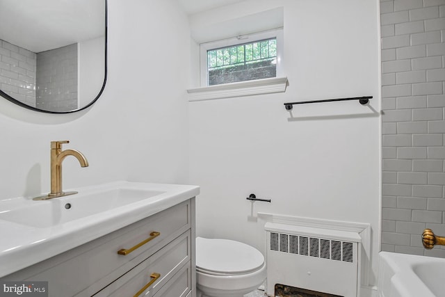 6911 Wells Pkwy, University Park, MD 20782 - bathroom featuring radiator heating unit, toilet, vanity, and bathing tub / shower combination