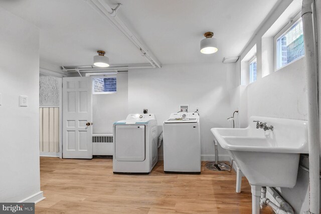 6911 Wells Pkwy, University Park, MD 20782 - clothes washing area featuring washer and dryer, light wood-style flooring, radiator heating unit, and baseboards