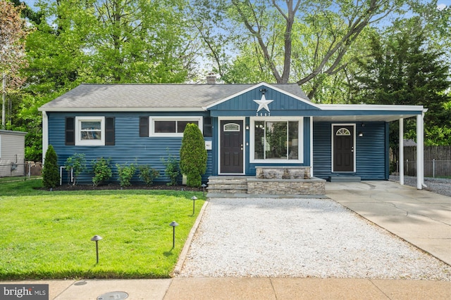 single story home with fence, an attached carport, concrete driveway, and a front yard
