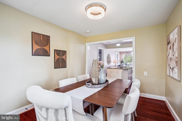 dining space featuring baseboards and wood finished floors