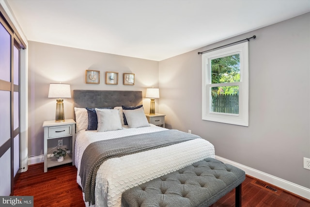 bedroom featuring visible vents, baseboards, and wood finished floors