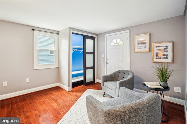 living area with baseboards and wood finished floors