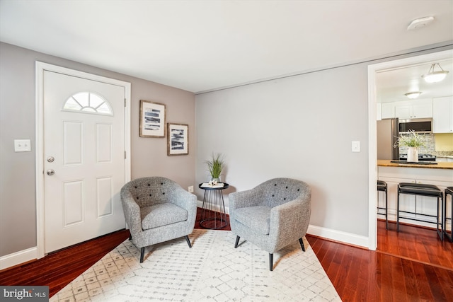 sitting room with baseboards and wood finished floors