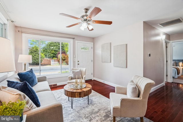 living area with baseboards, ceiling fan, dark wood-style floors, and visible vents