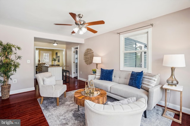 living room with baseboards, a ceiling fan, and wood finished floors