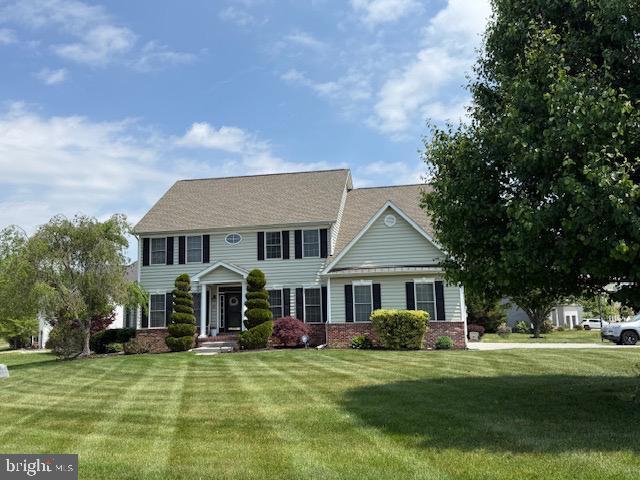colonial house featuring a front lawn