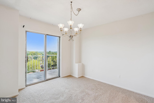 carpeted empty room with baseboards and a chandelier