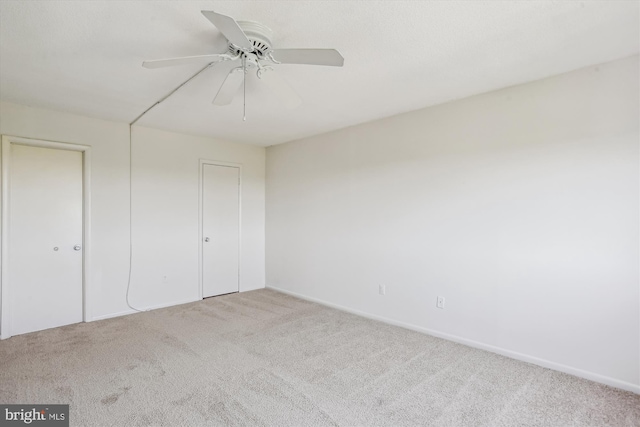 unfurnished bedroom featuring carpet floors, a ceiling fan, and baseboards