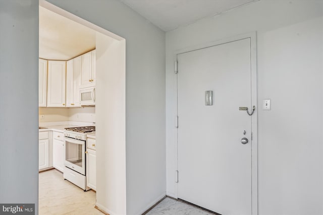 interior space with light countertops, white cabinets, and white appliances