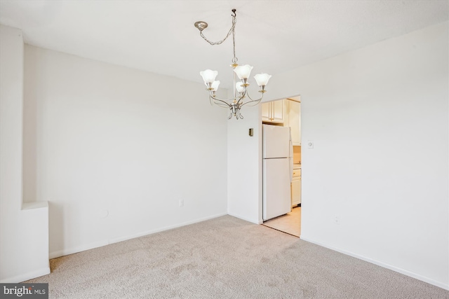unfurnished room featuring an inviting chandelier, baseboards, and light carpet