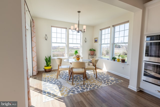 dining space with baseboards, dark wood-style flooring, and a chandelier