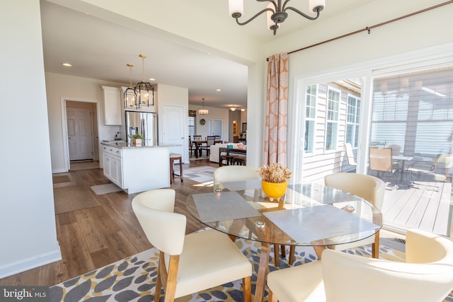 dining room featuring recessed lighting, baseboards, a notable chandelier, and light wood-type flooring