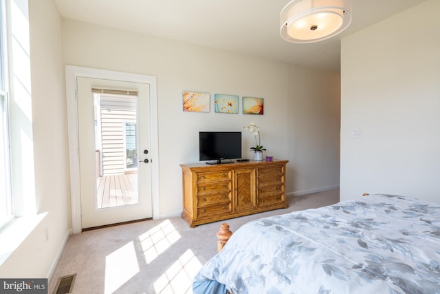bedroom with baseboards, light carpet, and visible vents
