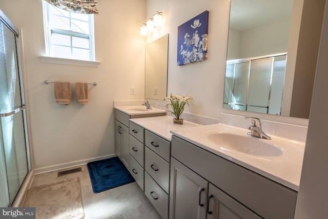 full bath featuring double vanity, visible vents, a sink, and a stall shower