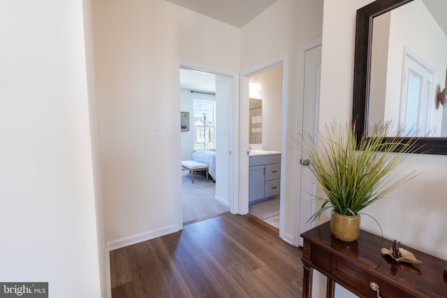 corridor featuring baseboards and wood finished floors