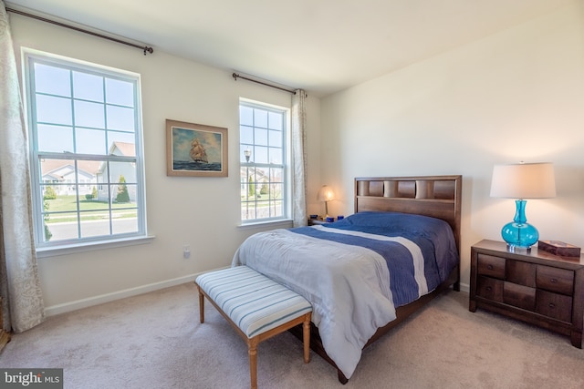 bedroom with carpet flooring, baseboards, and multiple windows