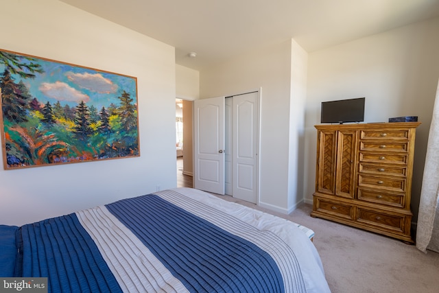 bedroom featuring a closet, baseboards, and light carpet
