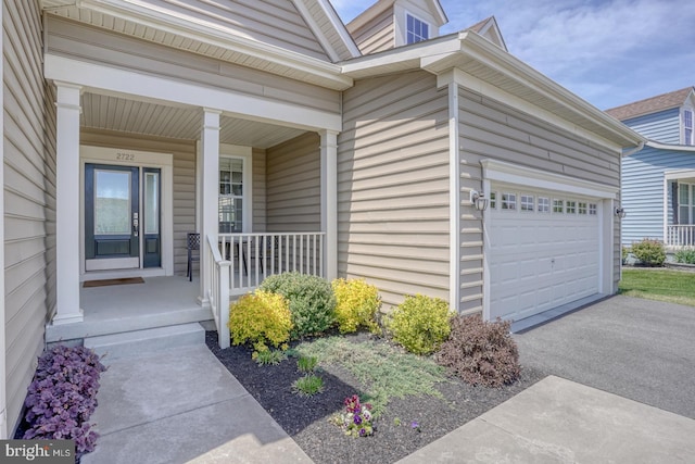 view of exterior entry with covered porch and driveway
